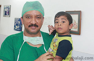 The child with Dr. S.M. Balaji after dental implant surgery