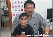 The child with Dr. S.M. Balaji after dental implant surgery